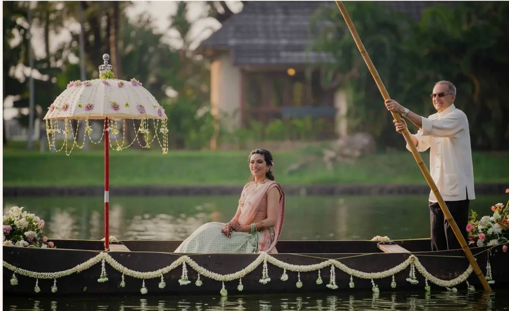 Bridal boat arrival beneath a floral parasol at The Zuri Kumarakom — completed Panigrahana work