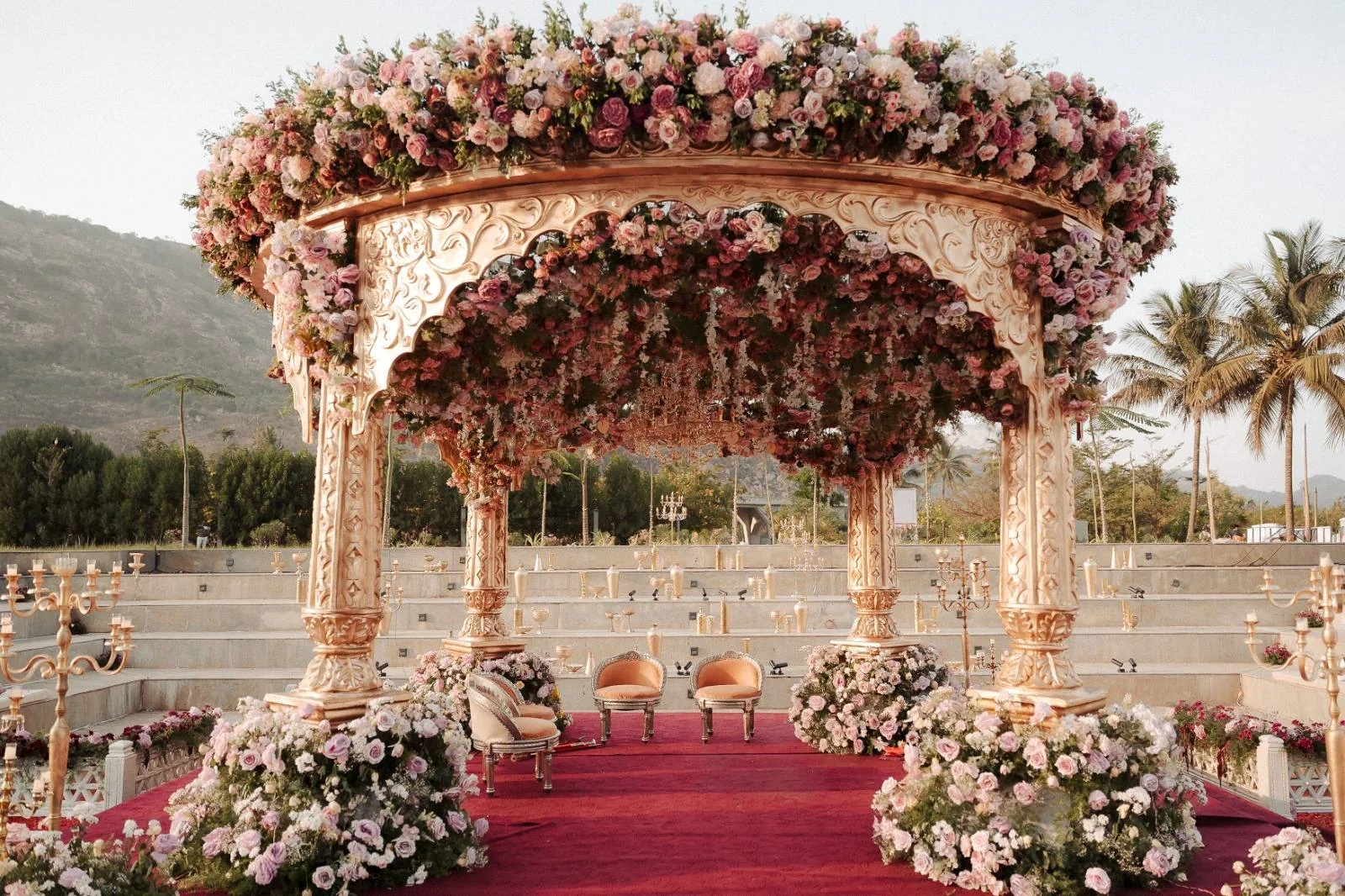 A pastel floral mandap surrounded by amphitheatre seating